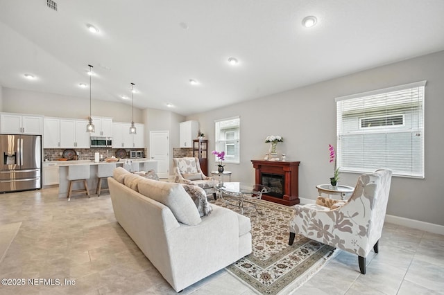 29 Lagoon Way, Palm Coast, FL 32137 - living area with vaulted ceiling, a glass covered fireplace, and recessed lighting