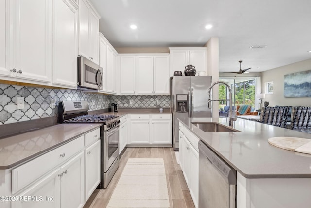 3146 Villa Vera Ct, Jacksonville, FL 32246 - kitchen with stainless steel appliances, a kitchen island with sink, light wood finished floors, white cabinets, and recessed lighting
