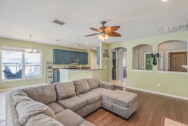 3350 Silverado Cir, Green Cove Springs, FL 32043 - living area with dark wood-style floors, arched walkways, ceiling fan, a textured ceiling, and a chandelier