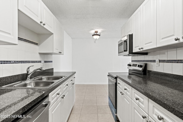 355 Monument Rd Unit 15D1, Jacksonville, FL 32225 - kitchen featuring appliances with stainless steel finishes, tasteful backsplash, white cabinets, light tile patterned flooring, and a textured ceiling