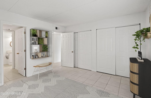 355 Monument Rd Unit 15D1, Jacksonville, FL 32225 - bedroom with two closets and light tile patterned flooring