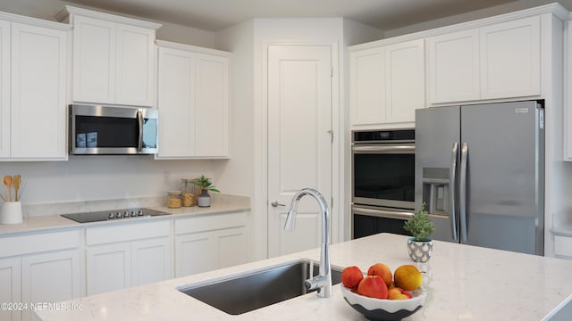 324 Higgins Loop, Saint Augustine, FL 32092 - kitchen with stainless steel appliances, white cabinetry, and light stone countertops