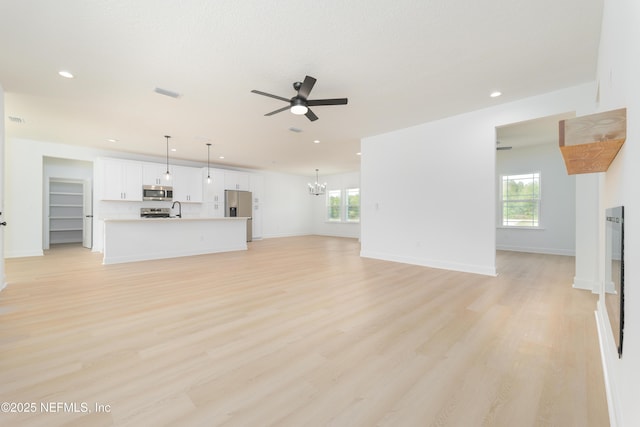 1861 Openwoods Rd, Middleburg, FL 32068 - unfurnished living room with ceiling fan, plenty of natural light, recessed lighting, light wood-style floors, and a chandelier