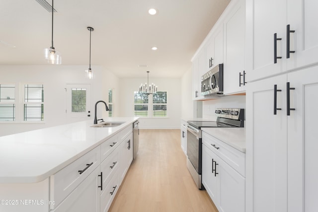 1861 Openwoods Rd, Middleburg, FL 32068 - kitchen featuring stainless steel appliances, light wood-style flooring, recessed lighting, light countertops, and decorative light fixtures