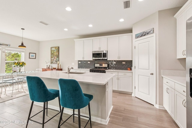 148 Ancient Island Dr, Saint Augustine, FL 32080 - kitchen featuring stainless steel microwave, gas stove, tasteful backsplash, light countertops, and a breakfast bar