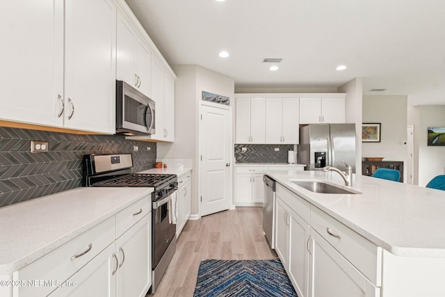 148 Ancient Island Dr, Saint Augustine, FL 32080 - kitchen featuring appliances with stainless steel finishes, light wood finished floors, backsplash, white cabinets, and light countertops