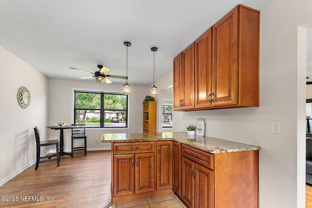 455 Aiken Rd, Jacksonville, FL 32216 - kitchen with brown cabinetry, ceiling fan, and light stone countertops