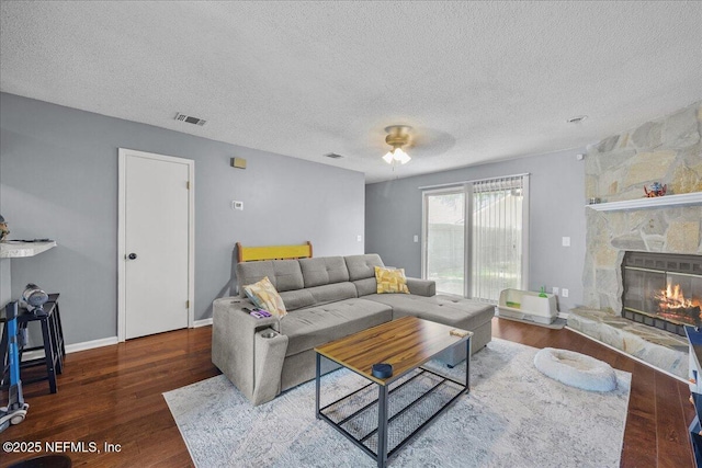 7632 Rain Forest Dr W, Jacksonville, FL 32277 - living room with a textured ceiling, wood finished floors, a fireplace, and ceiling fan