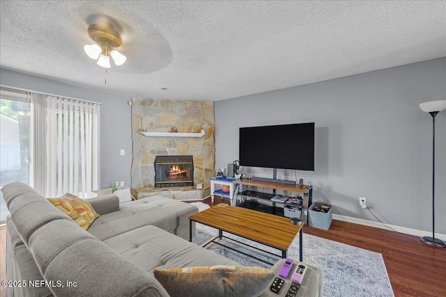 7632 Rain Forest Dr W, Jacksonville, FL 32277 - living area featuring a textured ceiling, a fireplace, a ceiling fan, and wood finished floors
