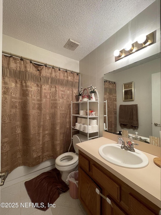 1038 Celebrant Dr, Jacksonville, FL 32225 - bathroom with a textured ceiling, vanity, and tile walls