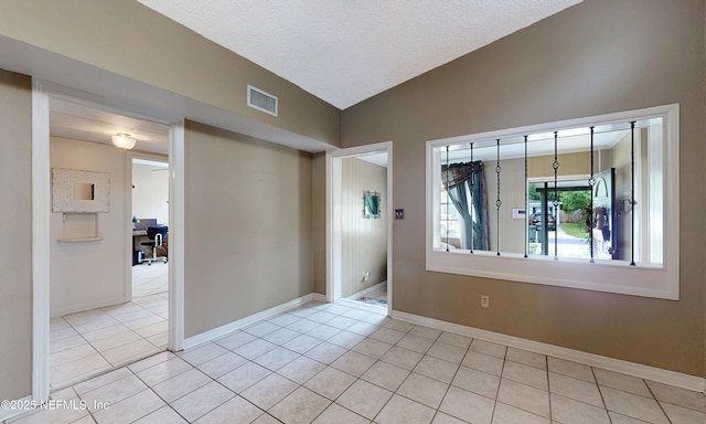 5110 Janice Cir E, Jacksonville, FL 32210 - empty room with an office area, light tile patterned flooring, lofted ceiling, and a textured ceiling