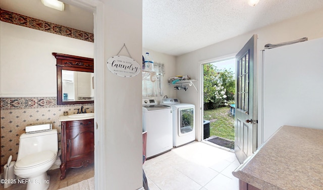 5110 Janice Cir E, Jacksonville, FL 32210 - washroom with washing machine and dryer, light tile patterned floors, a textured ceiling, and wainscoting