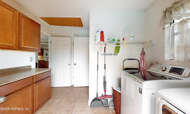 5110 Janice Cir E, Jacksonville, FL 32210 - laundry area featuring cabinet space, attic access, independent washer and dryer, and light tile patterned floors