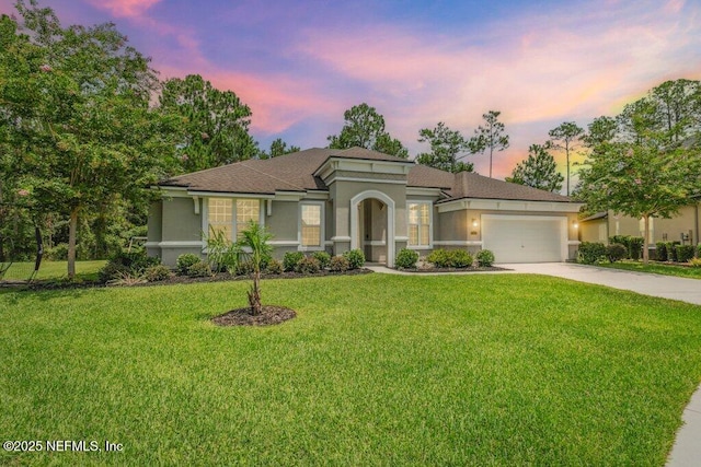 1103 Orchard Oriole Pl, Middleburg, FL 32068 - mediterranean / spanish house featuring an attached garage, stucco siding, concrete driveway, and a yard