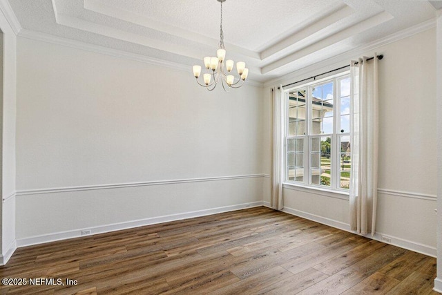 1103 Orchard Oriole Pl, Middleburg, FL 32068 - spare room with a tray ceiling, wood finished floors, a chandelier, and ornamental molding