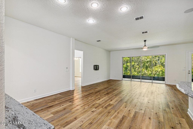 1103 Orchard Oriole Pl, Middleburg, FL 32068 - unfurnished living room with a ceiling fan, a textured ceiling, and light wood finished floors