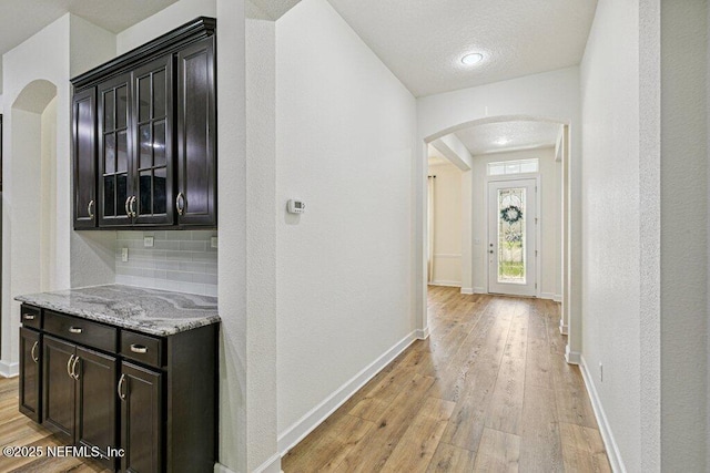 1103 Orchard Oriole Pl, Middleburg, FL 32068 - hall with arched walkways, light wood-type flooring, and a textured wall