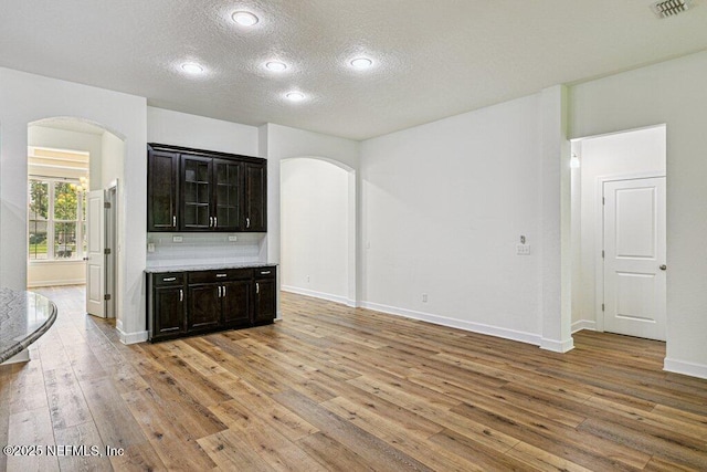 1103 Orchard Oriole Pl, Middleburg, FL 32068 - interior space with arched walkways, a textured ceiling, light wood-style flooring, recessed lighting, and tasteful backsplash
