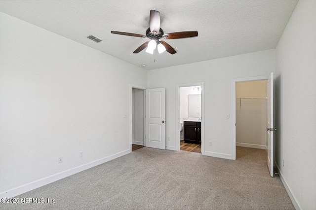 1103 Orchard Oriole Pl, Middleburg, FL 32068 - unfurnished bedroom with a spacious closet, carpet, ensuite bathroom, a ceiling fan, and a textured ceiling