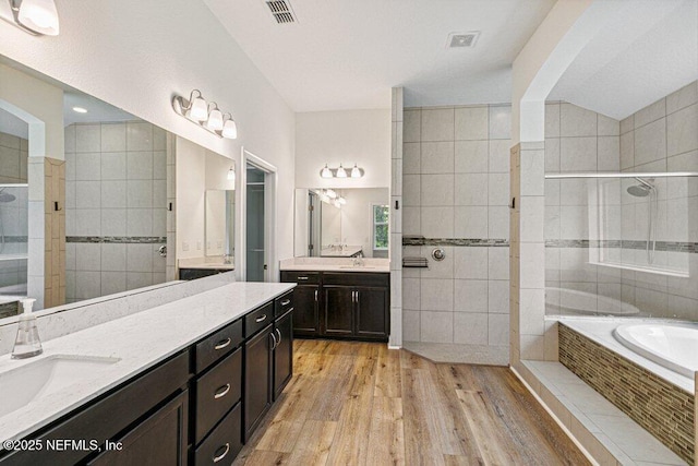 1103 Orchard Oriole Pl, Middleburg, FL 32068 - bathroom with a garden tub, wood finished floors, two vanities, and a walk in shower
