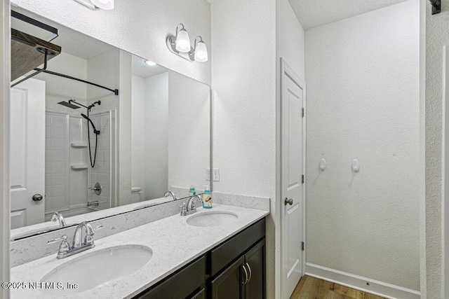 1103 Orchard Oriole Pl, Middleburg, FL 32068 - bathroom with wood finished floors, double vanity, tub / shower combination, and a textured wall