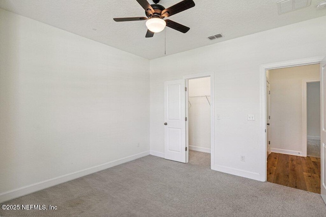 1103 Orchard Oriole Pl, Middleburg, FL 32068 - unfurnished bedroom featuring carpet flooring, a spacious closet, a textured ceiling, and a ceiling fan
