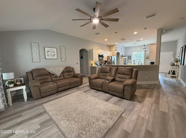 51321 Bloomington Way, Callahan, FL 32011 - living room with ceiling fan, arched walkways, light wood-style flooring, lofted ceiling, and recessed lighting