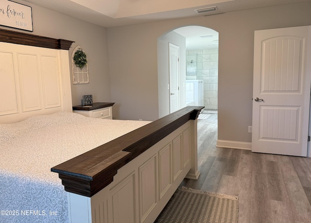 51321 Bloomington Way, Callahan, FL 32011 - kitchen featuring arched walkways, dark countertops, white cabinets, and wood finished floors