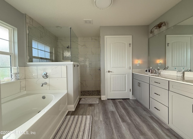 51321 Bloomington Way, Callahan, FL 32011 - full bathroom featuring a garden tub, vanity, a tile shower, and wood finished floors