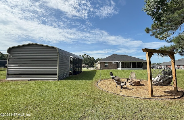 51321 Bloomington Way, Callahan, FL 32011 - view of grassy yard with a sunroom and a fire pit