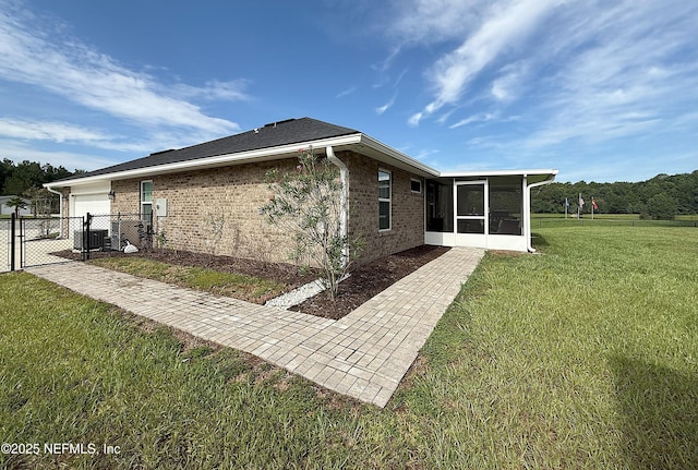 51321 Bloomington Way, Callahan, FL 32011 - rear view of property featuring a sunroom, a gate, a garage, and brick siding