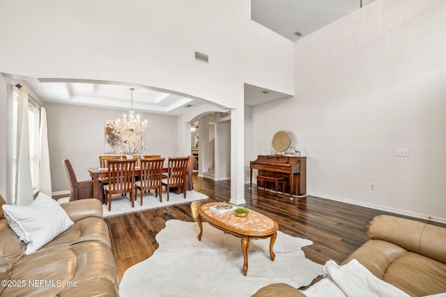 1020 Candlebark Dr, Jacksonville, FL 32225 - living area with arched walkways, wood finished floors, a chandelier, and a tray ceiling
