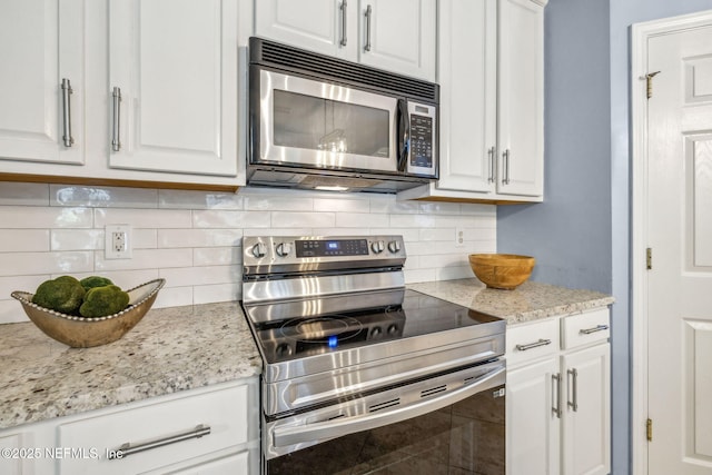 1020 Candlebark Dr, Jacksonville, FL 32225 - kitchen featuring appliances with stainless steel finishes, white cabinetry, tasteful backsplash, and light stone counters