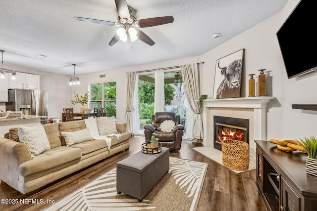 1020 Candlebark Dr, Jacksonville, FL 32225 - living room with dark wood-style flooring, a textured ceiling, ceiling fan, and a tiled fireplace