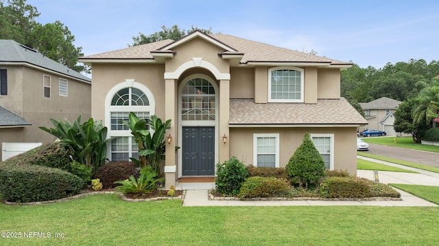1020 Candlebark Dr, Jacksonville, FL 32225 - traditional home featuring stucco siding, a front lawn, and roof with shingles