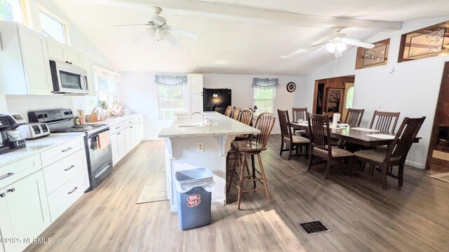 3822 County Road 220, Middleburg, FL 32068 - kitchen featuring stainless steel appliances, ceiling fan, light wood-style flooring, and a breakfast bar