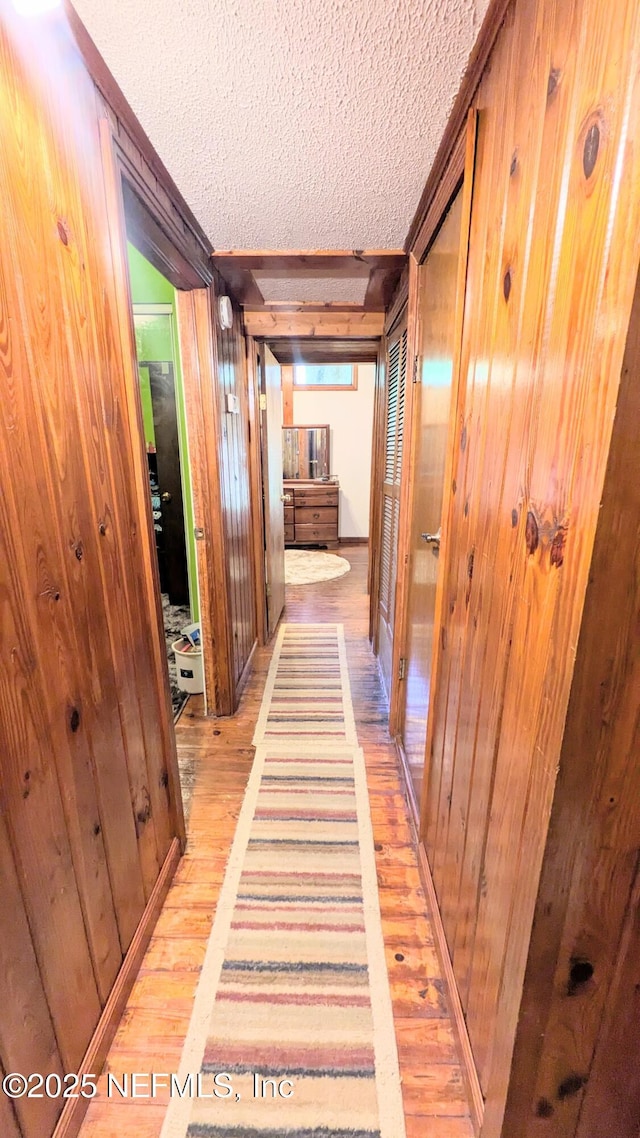 3822 County Road 220, Middleburg, FL 32068 - hall with a textured ceiling, light wood finished floors, and wooden walls