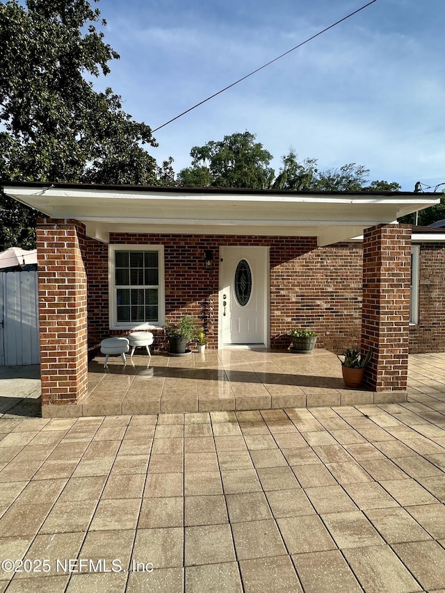 8300 Berry, Jacksonville, FL 32211 - view of exterior entry featuring a patio and brick siding