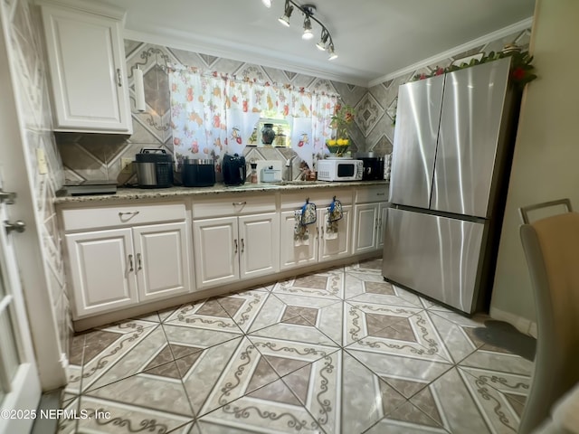 8300 Berry, Jacksonville, FL 32211 - kitchen featuring freestanding refrigerator, white microwave, ornamental molding, light tile patterned floors, and white cabinets