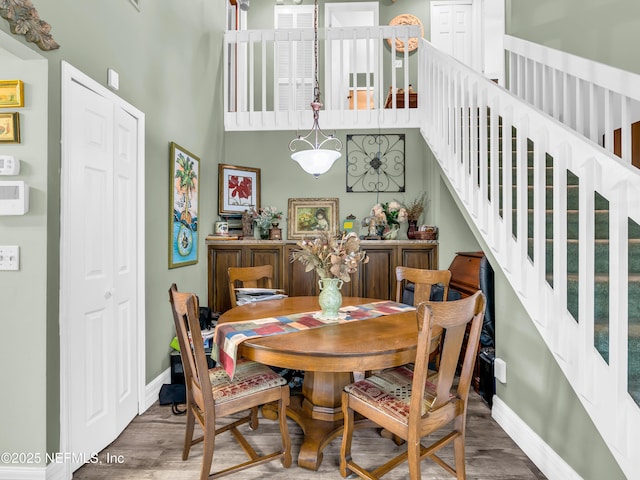 335 Sunrise Cir, Neptune Beach, FL 32266 - dining space with stairway, wood finished floors, and a high ceiling