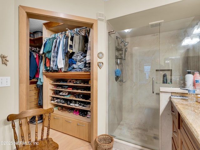 335 Sunrise Cir, Neptune Beach, FL 32266 - full bath featuring a shower stall, vanity, a walk in closet, and wood finished floors