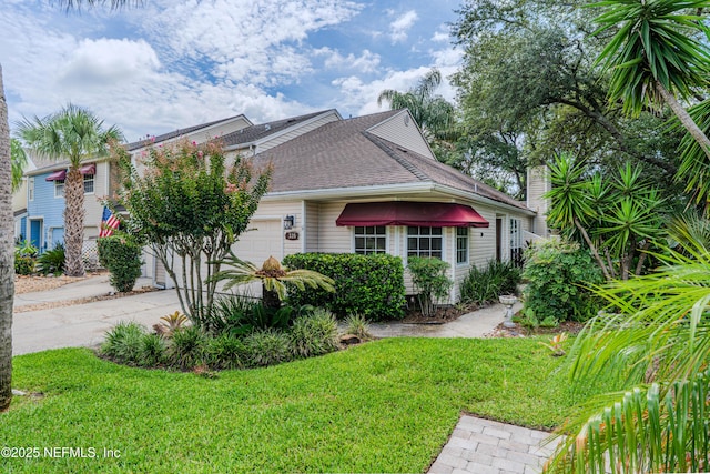 335 Sunrise Cir, Neptune Beach, FL 32266 - view of side of home featuring a yard, roof with shingles, a garage, and driveway