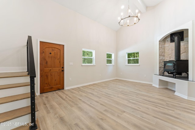 343 Tinsley Rd, Florahome, FL 32140 - unfurnished living room with a wood stove, high vaulted ceiling, a chandelier, stairs, and light wood-style floors
