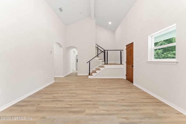 343 Tinsley Rd, Florahome, FL 32140 - foyer featuring stairway, high vaulted ceiling, arched walkways, beam ceiling, and light wood-style floors