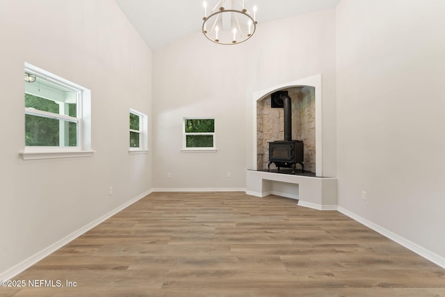 343 Tinsley Rd, Florahome, FL 32140 - unfurnished living room with a chandelier, a wood stove, wood finished floors, and high vaulted ceiling