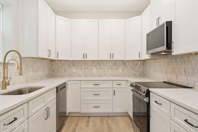 343 Tinsley Rd, Florahome, FL 32140 - kitchen featuring stainless steel appliances, light countertops, white cabinets, and light wood-type flooring
