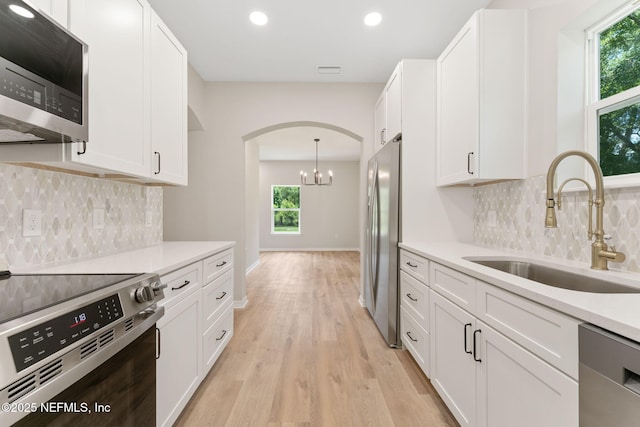 343 Tinsley Rd, Florahome, FL 32140 - kitchen with stainless steel appliances, arched walkways, light wood-type flooring, white cabinetry, and recessed lighting