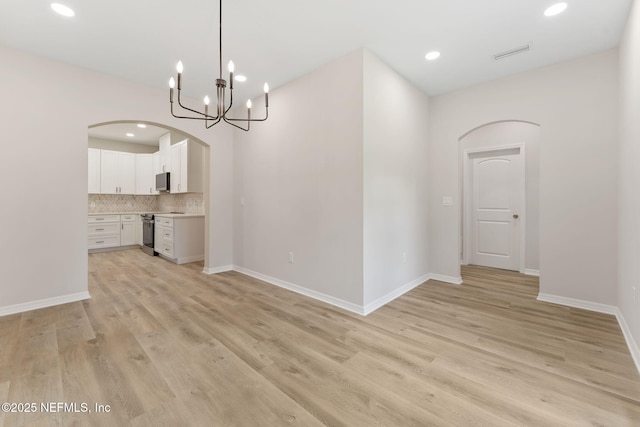 343 Tinsley Rd, Florahome, FL 32140 - unfurnished dining area featuring arched walkways, a chandelier, light wood-type flooring, and recessed lighting