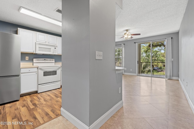 4000 Grande Vista Blvd Unit 15-106, Saint Augustine, FL 32084 - kitchen featuring white appliances, a textured ceiling, a ceiling fan, white cabinets, and light countertops