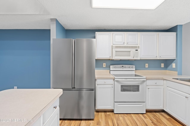 4000 Grande Vista Blvd Unit 15-106, Saint Augustine, FL 32084 - kitchen featuring white appliances, light countertops, white cabinets, and a textured ceiling